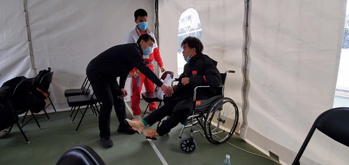 图为省残联党组书记、理事长吴玉新赛后看望受伤运动员