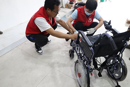 图为辅具工程师现场为残疾人组装电动轮椅
